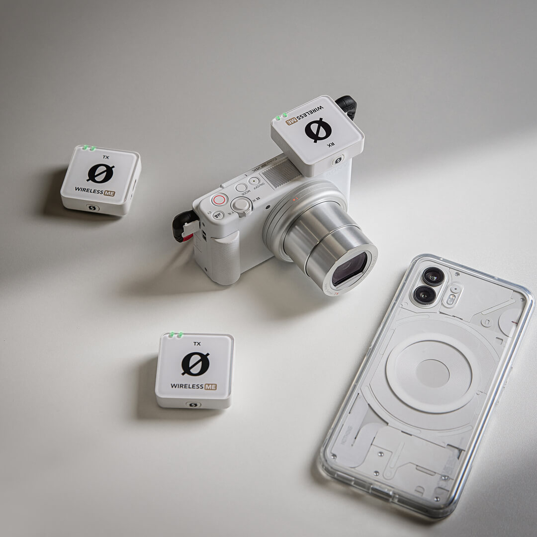 Wireless ME Dual (White) on tabletop with camera and phone case
